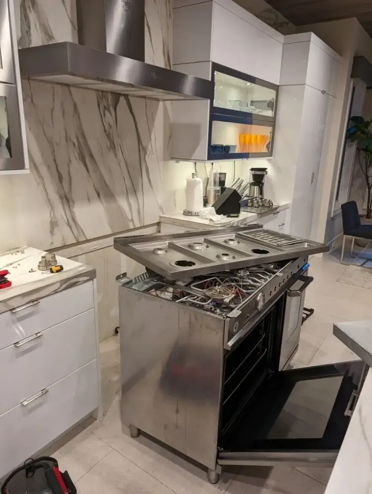 Professional-style range with the cooktop raised for burner and valve service
