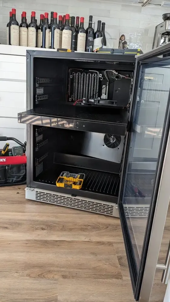 Undercounter wine refrigerator opened for a cooling repair
